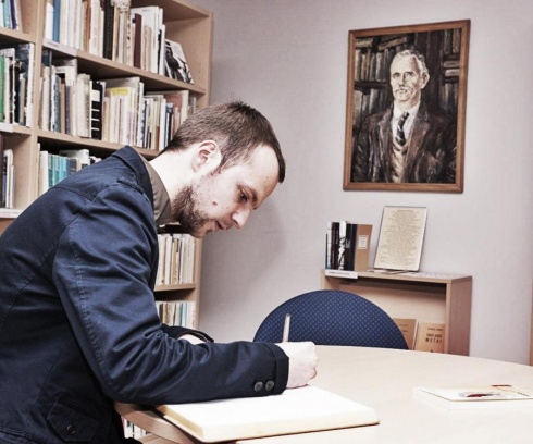 Tomas Vaiseta rašo įspūdžius svečių knygoje Panevėžio G. Petkevičaitės-Bitės viešosios bibliotekos K. Barėno skaitykloje